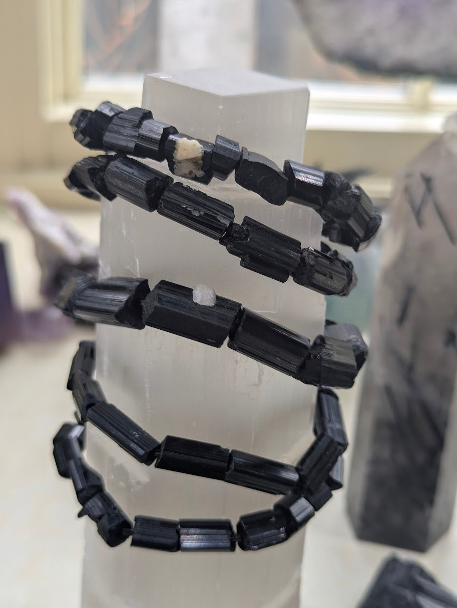 aw Black Tourmaline bracelets wrapped around a Selenite tower to highlight the contrast between minerals.