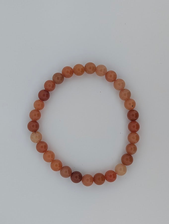 Top-down view of 6mm red aventurine bracelet on white background