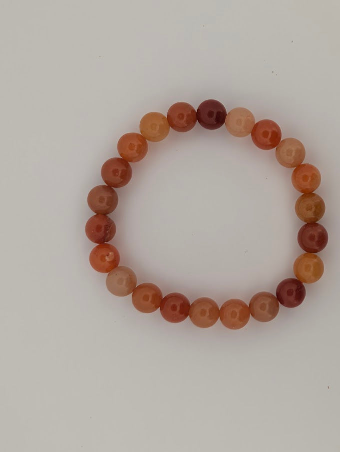 Top-down view of 8mm red aventurine bracelet on white background