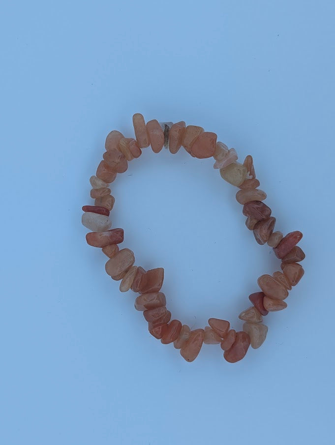 Top-down view of chip red aventurine bracelet on white background