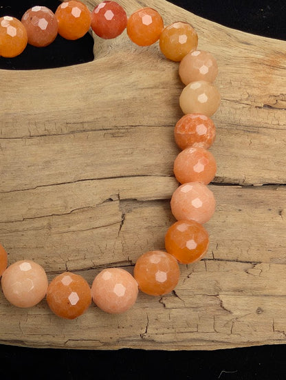 Macro close-up of 8mm faceted Red Aventurine beads highlighting the sharp lapidary cuts and natural shimmering aventurescence.
