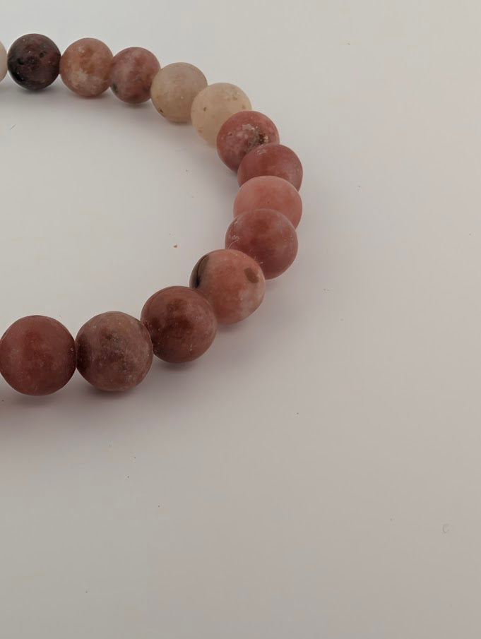 Detail of 6mm bracelet with soft terracotta reds and dark septarian veining