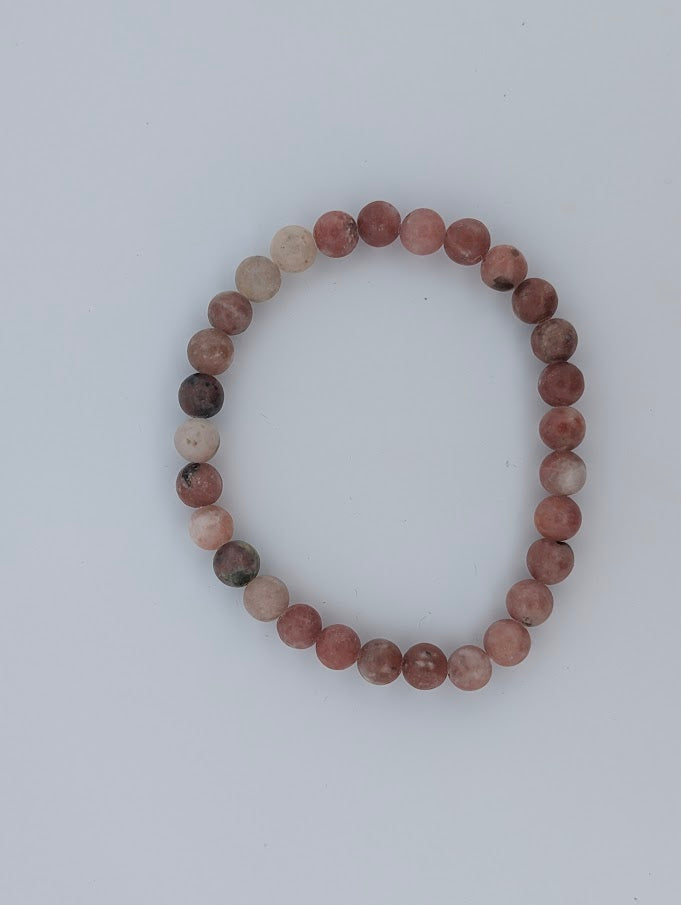 Top-down view of 6mm red aventurine with septarian bracelet on white background