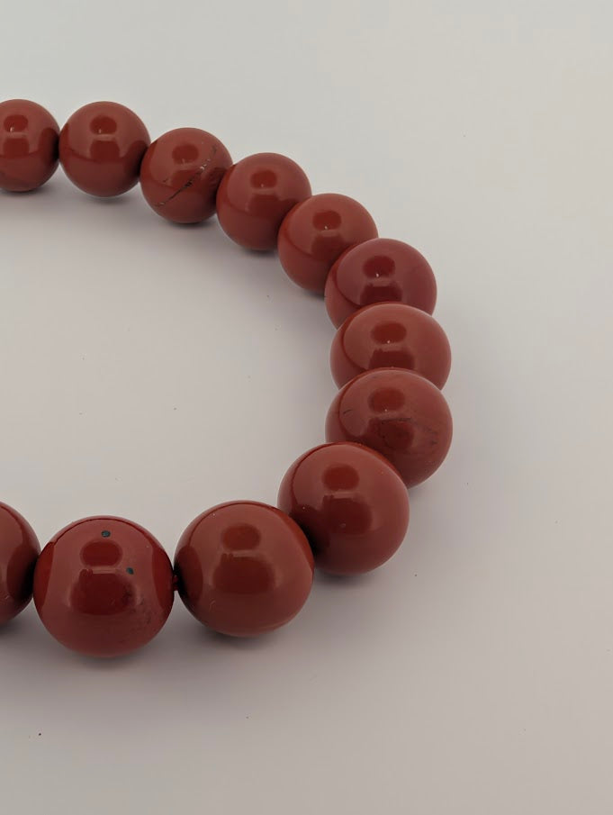 Detail of 8mm red jasper beads with glossy finish