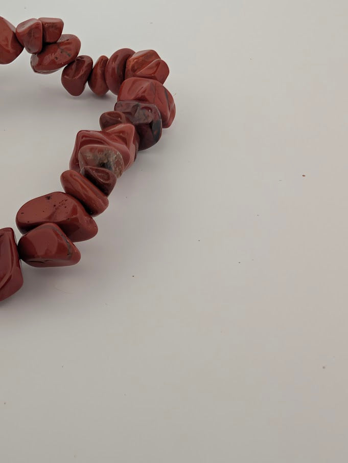Detail of red jasper chip bracelet with glossy polish and uniform red tones