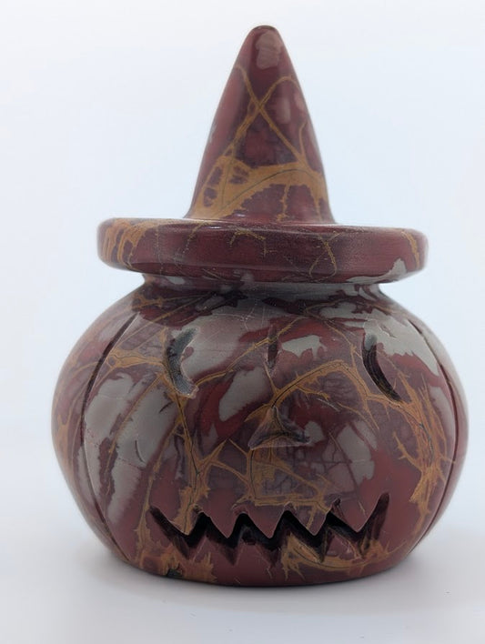 Red jasper pumpkin witch hat carving – front view with carved face