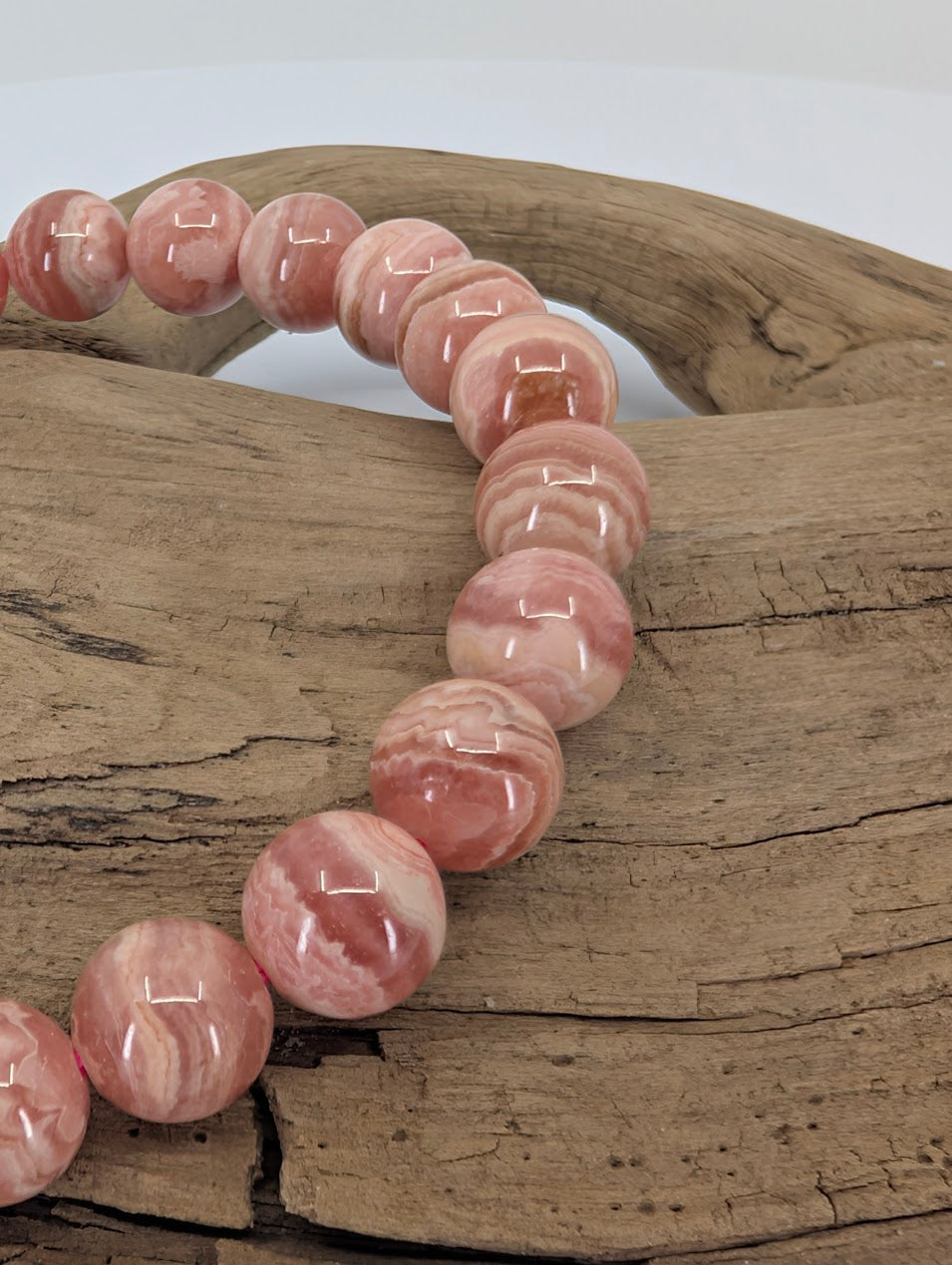 Close-up of pink banded rhodochrosite beads with high polish