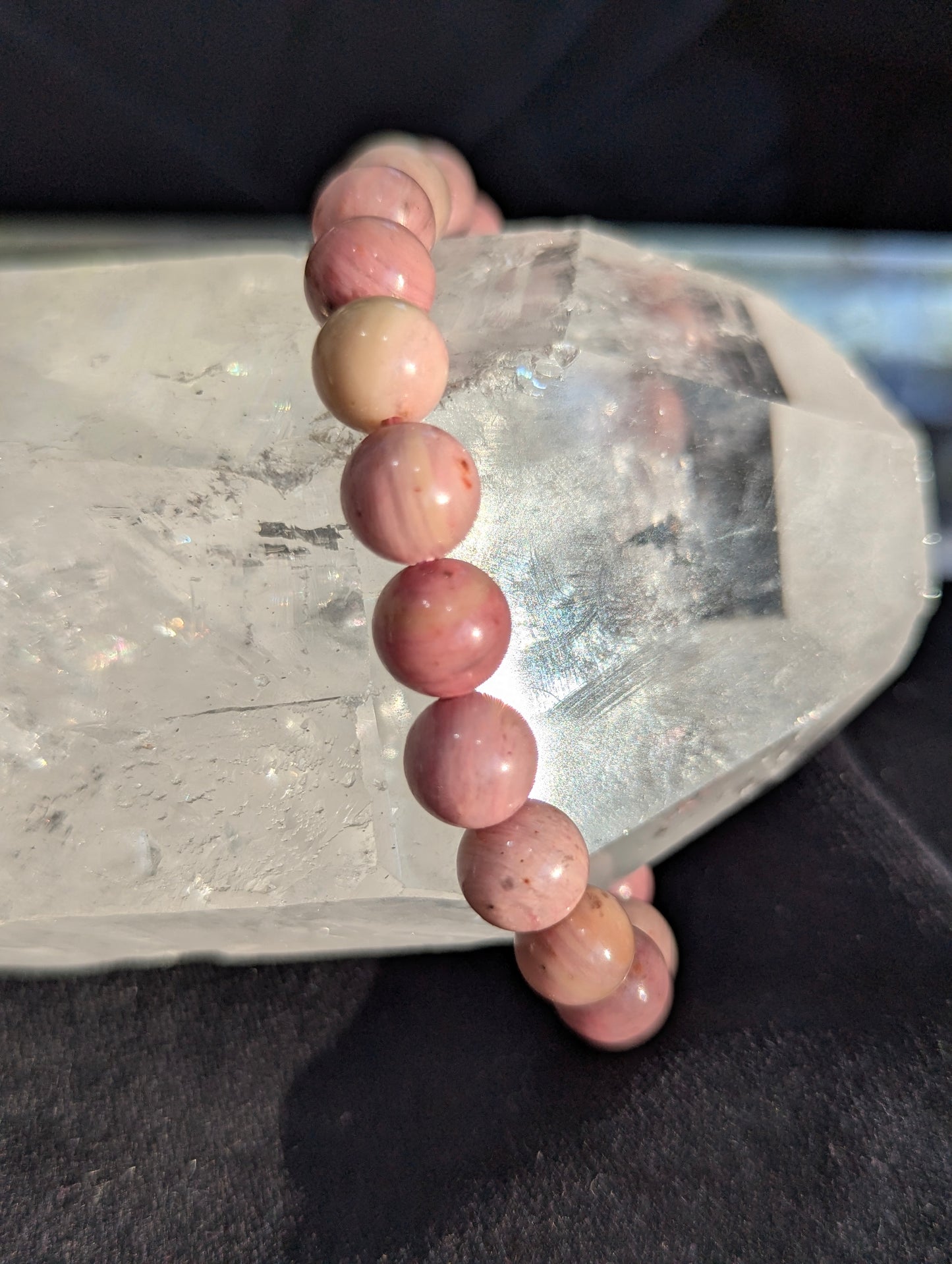 Macro close-up view of polished 8mm Blush Rhodonite spheres, highlighting the vitreous luster and pristine pink stone matrix free of heavy dark manganese oxides.