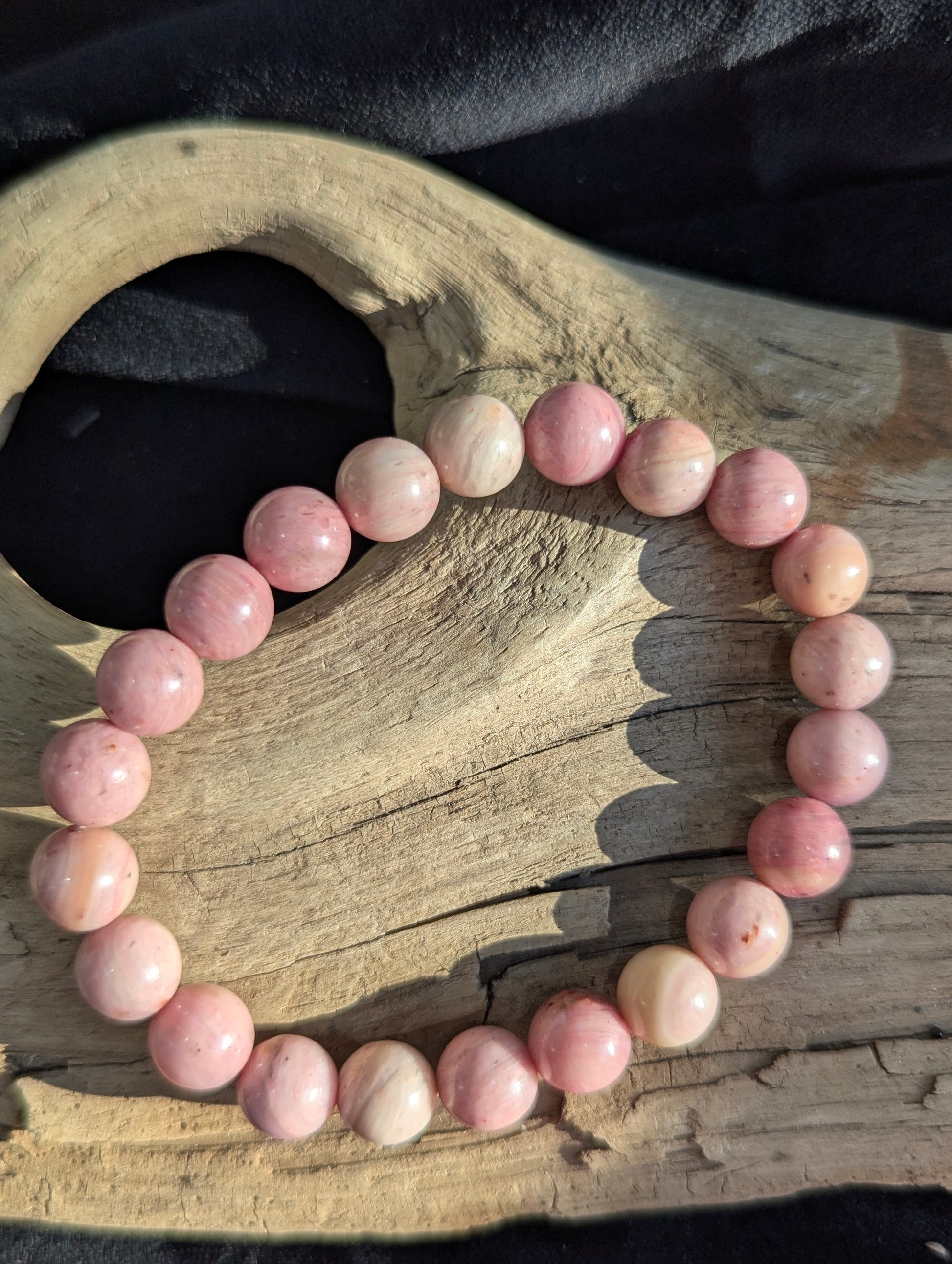 Premium 8mm Blush Rhodonite beaded stretch bracelet displayed on a wrist to demonstrate its 17cm (6.69") diameter scale and continuous structural profile under balanced lighting.