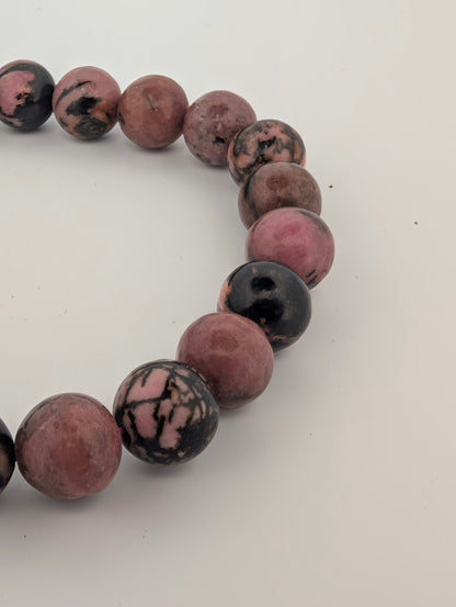 Close detail of 8mm rhodonite beads showing polished finish and natural veining