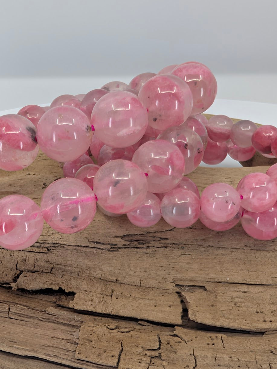 Close-up of Madagascar rhodonite beads showing natural pink coloration and internal mineral inclusions