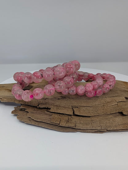 Natural rhodonite bracelet from Madagascar with polished pink beads and quartz-hosted translucency