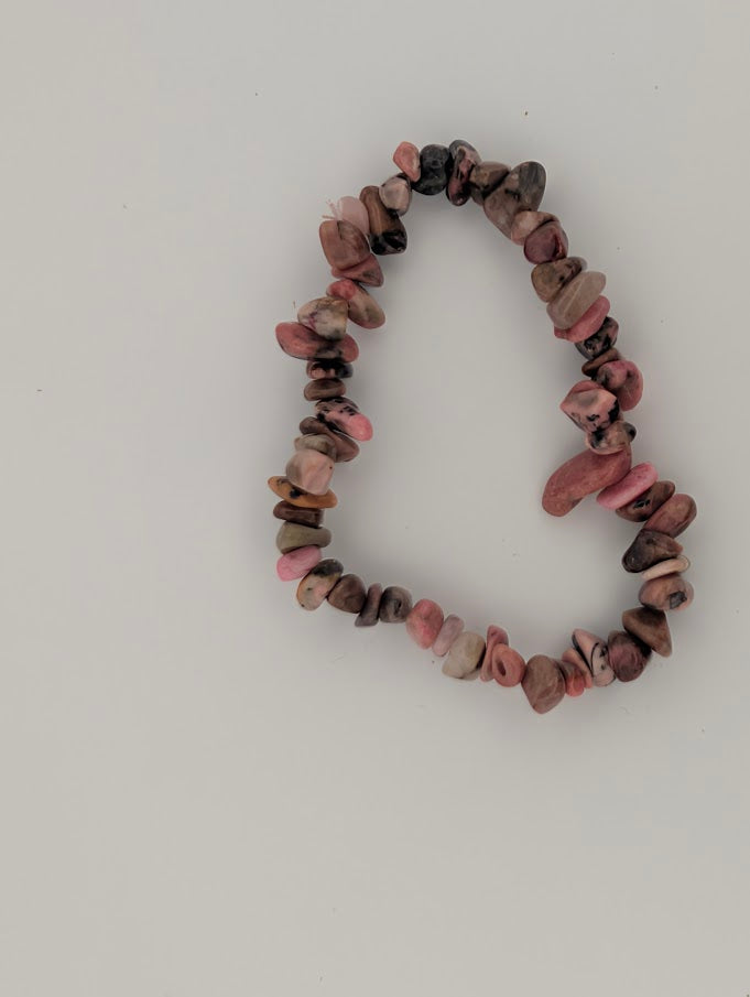 Top-down view of rhodonite chip bracelet on white background