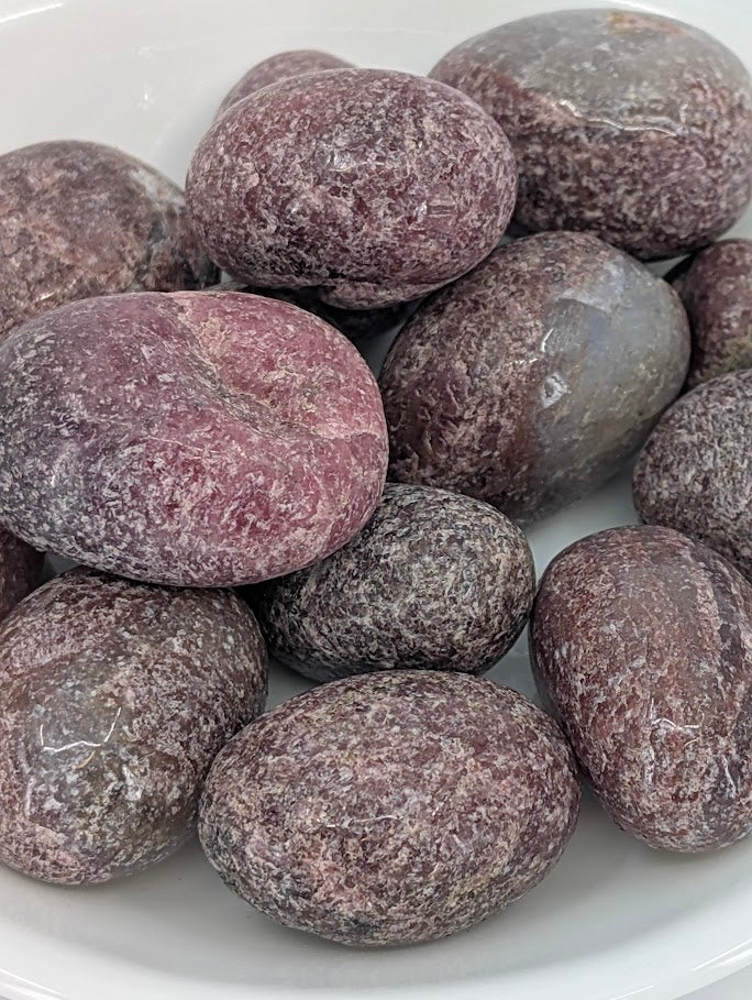 Close-up of Rhodonite tumbled stones showing pink manganese veining