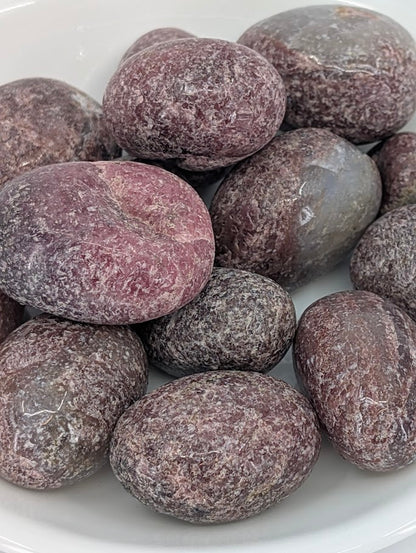 Close-up of Rhodonite tumbled stones showing pink manganese veining