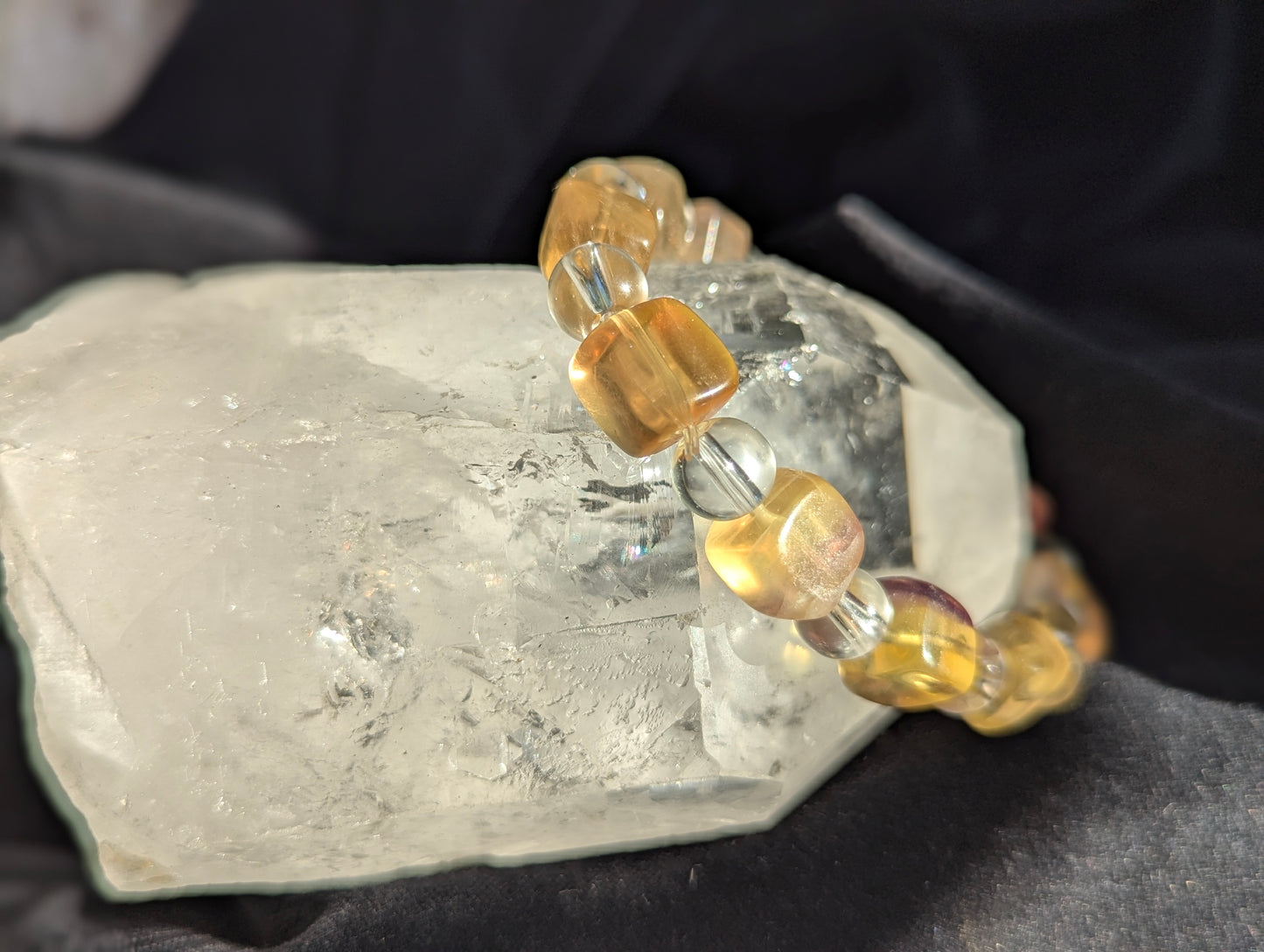 Premium yellow fluorite and clear quartz beaded stretch bracelet displayed on a hand model, demonstrating the 30 gram weight and continuous structural profile.