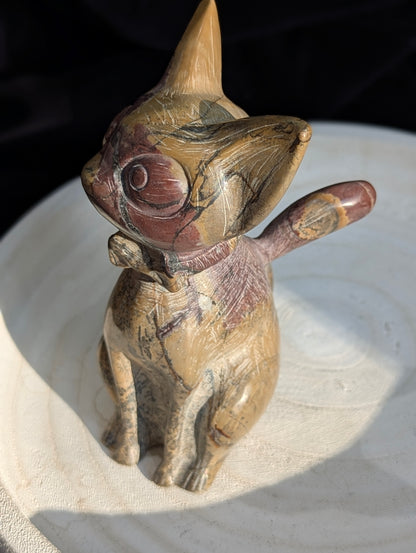 Hand-carved Picture Jasper crystal cat figurine wearing a bowtie, displaying natural tan and reddish-brown banded earthy patterns, sitting upright.