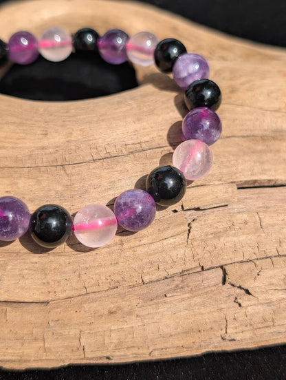 Macro close-up of 8mm Rose Quartz, Amethyst, and black Obsidian beads showing pink cord detail.
