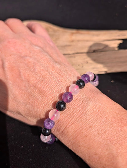 8mm Rose Quartz, Amethyst, and black Obsidian beaded bracelet worn on a wrist for size scale.