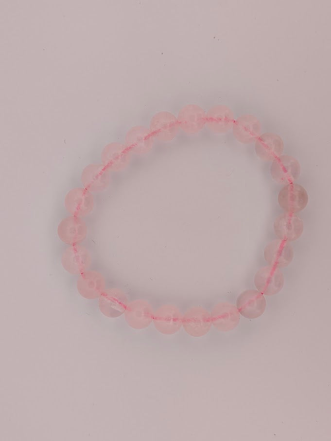 Top-down view of 8mm rose quartz bracelet on a white background