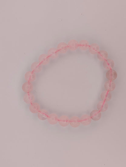Top-down view of 8mm rose quartz bracelet on a white background