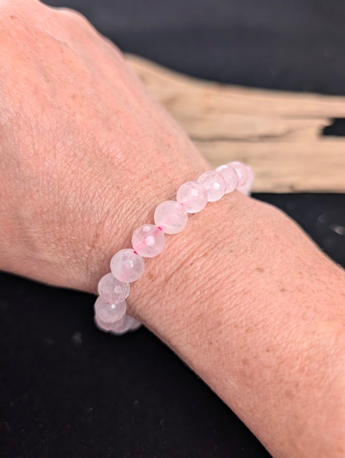 8mm faceted Rose Quartz beaded stretch bracelet worn on a wrist for size scale.
