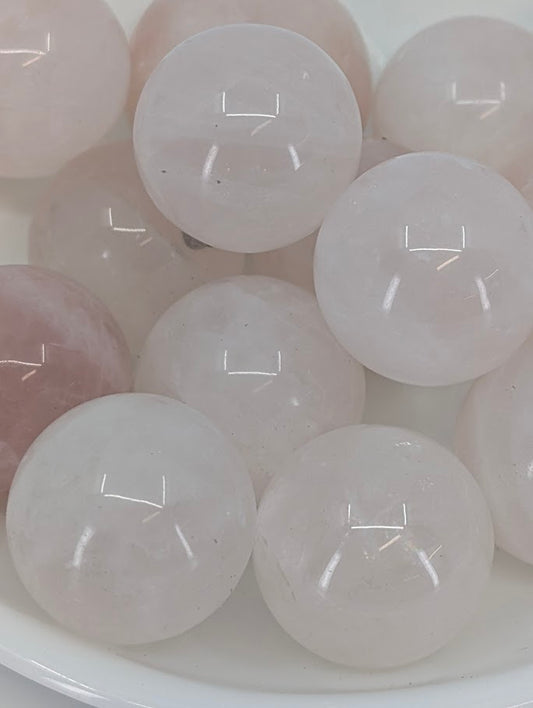 Close-up of polished Rose Quartz mini spheres showing pink translucency