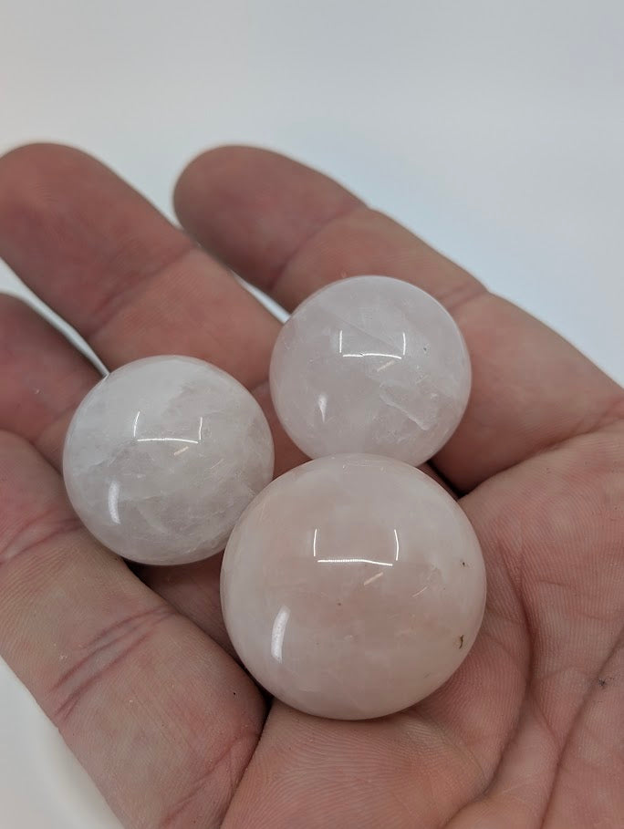 Rose Quartz mini spheres held in hand for size reference