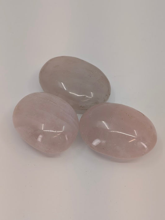 Rose Quartz palm stones showing gentle pink hue and polished translucent surface front view