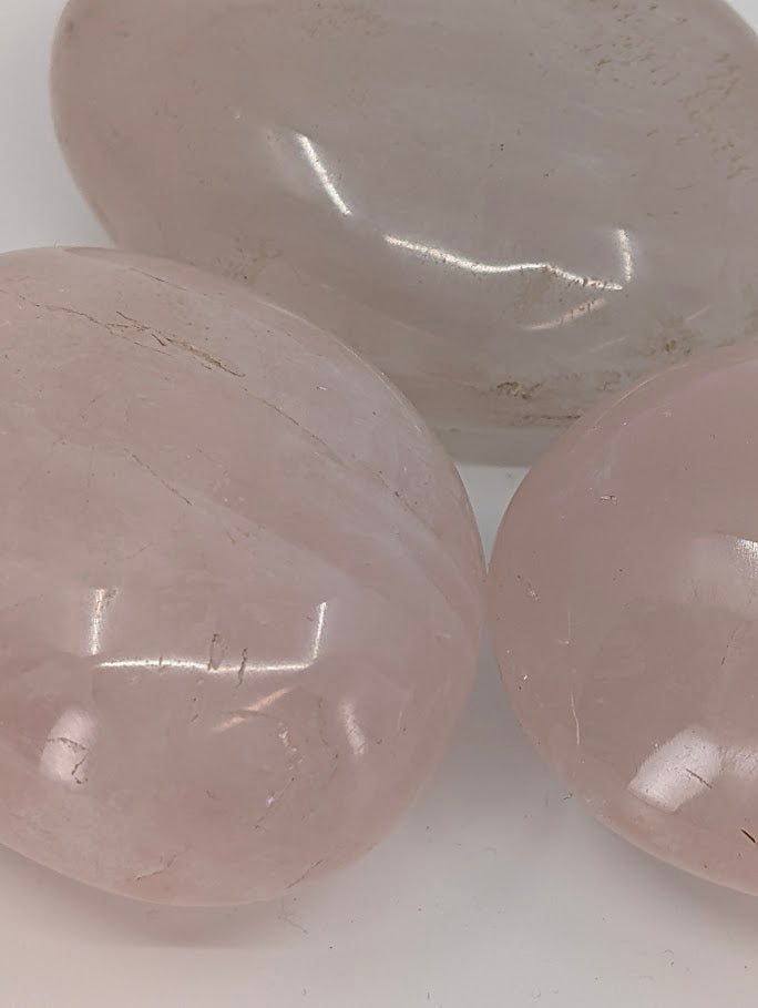 Rose Quartz palm stones grouped together showing soft blush tones and smooth polish
