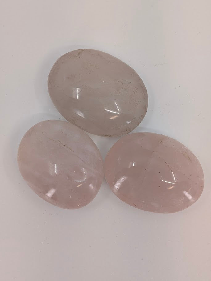 Close-up of Rose Quartz palm stones displaying internal veining and natural clarity