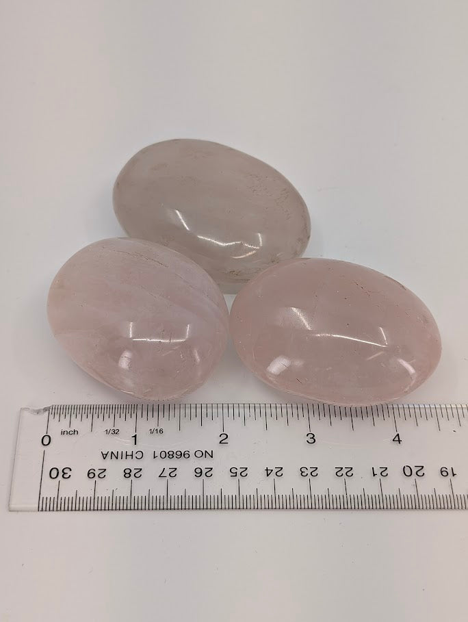 Rose Quartz palm stones with ruler for scale showing approximate size and transparency