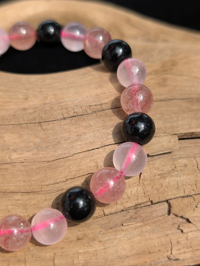 Macro close-up of 8mm Rose Quartz, Strawberry Quartz, and black Obsidian beads showing pink cord detail.