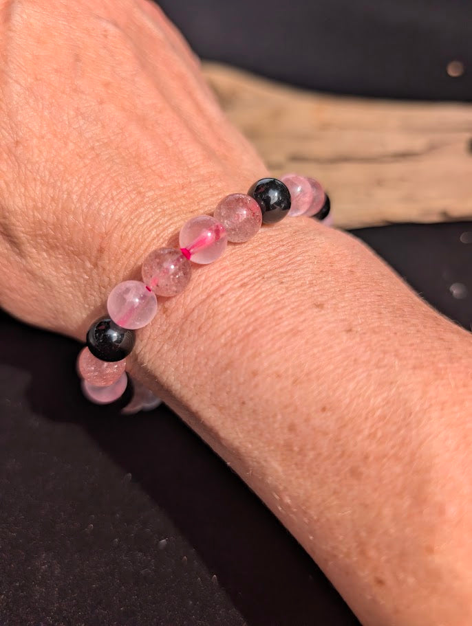 8mm Rose Quartz, Strawberry Quartz, and black Obsidian beaded bracelet worn on wrist for size scale.