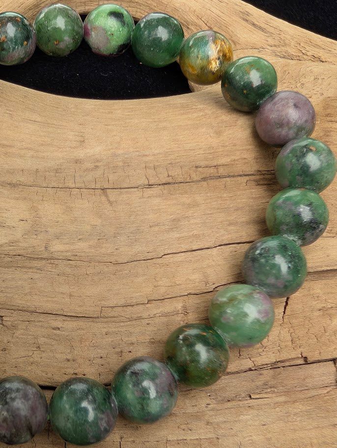 Macro close-up of 8mm polished Ruby in Fuchsite beads highlighting the high-gloss finish and the contrast between the green matrix and magenta ruby.