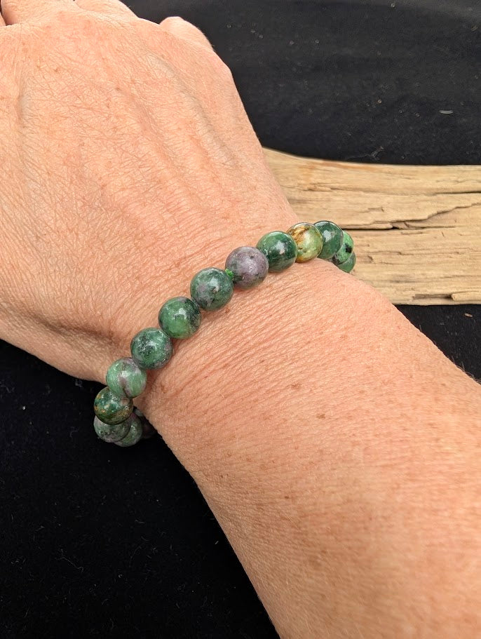 8mm polished Ruby in Fuchsite beaded stretch bracelet worn on a wrist for size scale.