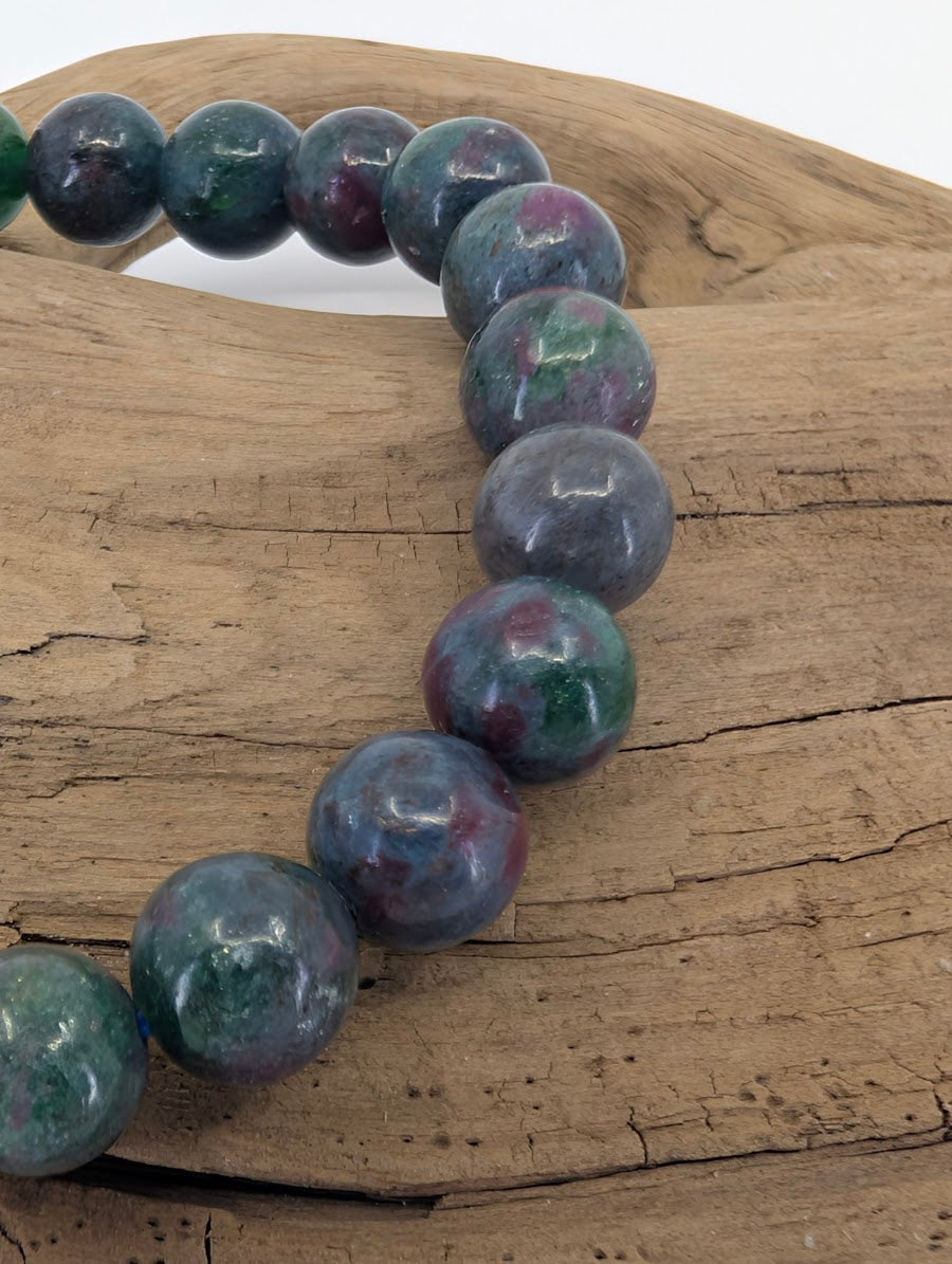 Close-up of 8mm Ruby in Kyanite beads highlighting the natural Corundum inclusions and high-gloss polish.