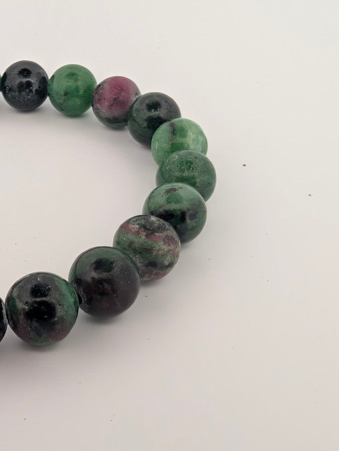 Detail of ruby in zoisite beads highlighting green zoisite, ruby spots, and polish