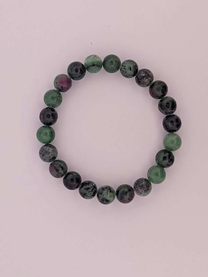 Top-down view of ruby in zoisite round bead bracelet on white background