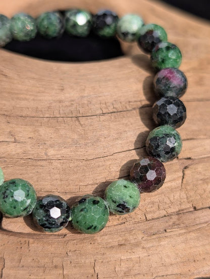 Macro close-up of 8mm faceted Ruby in Zoisite beads highlighting the geometric surface cuts and natural ruby inclusions.