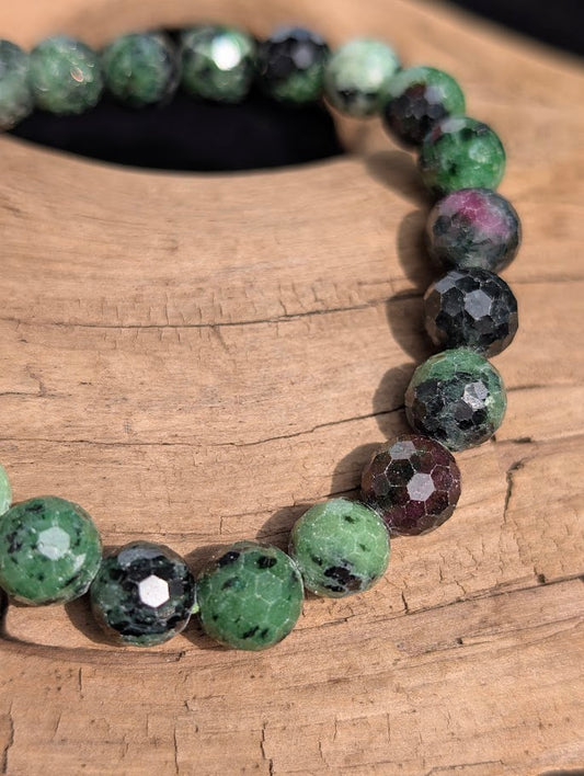 Macro close-up of 8mm faceted Ruby in Zoisite beads highlighting the geometric surface cuts and natural ruby inclusions.