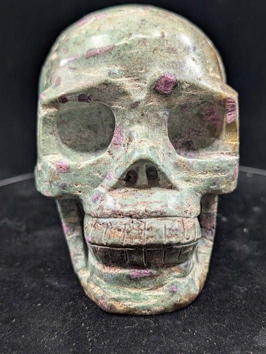 Ruby in Zoisite skull carving, front view showing teeth and eye sockets