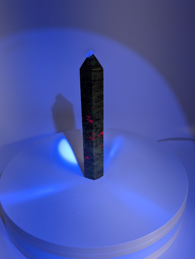 Ruby in Zoisite tower under UV light – fluorescent ruby sections