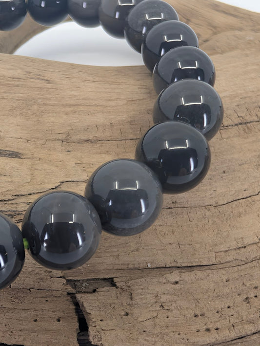 Closeup of Saffordite beads showing charcoal volcanic glass texture