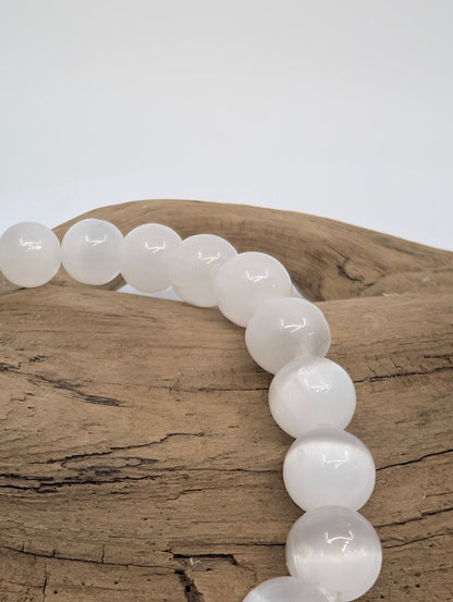 Close-up of polished 8MM Selenite bracelet beads with luminous glow