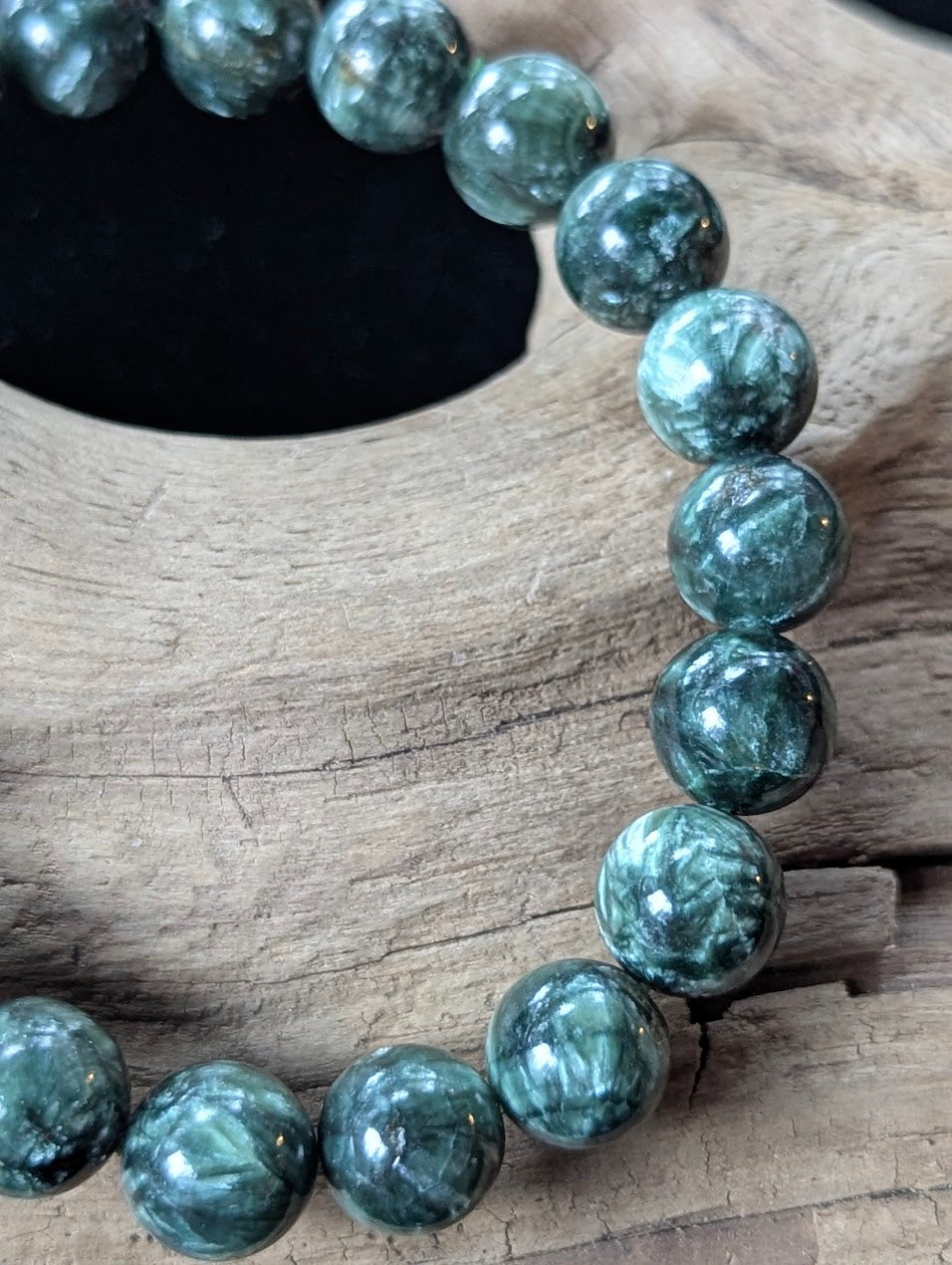 Close-up of 10mm Seraphinite (Clinochlore) Bracelet, showing deep forest green coloring and silver patterns.