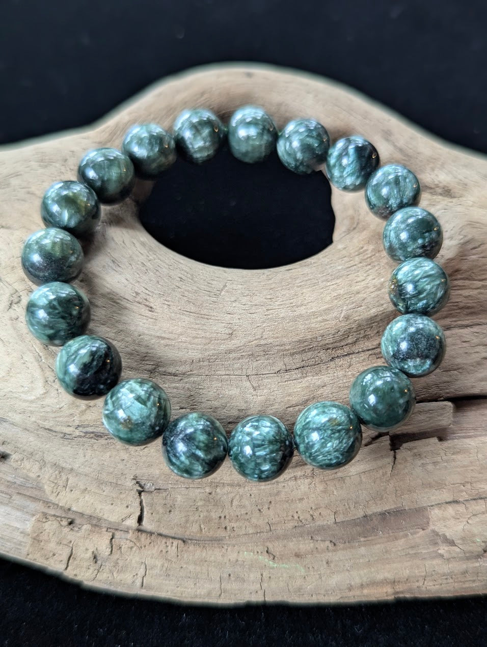 11mm Seraphinite (Clinochlore) Bracelet from Siberia, showcasing large beads with striking chatoyancy on driftwood