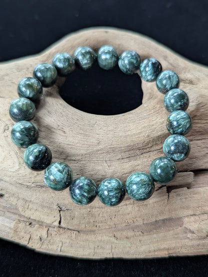 11mm Seraphinite (Clinochlore) Bracelet from Siberia, showcasing large beads with striking chatoyancy on driftwood