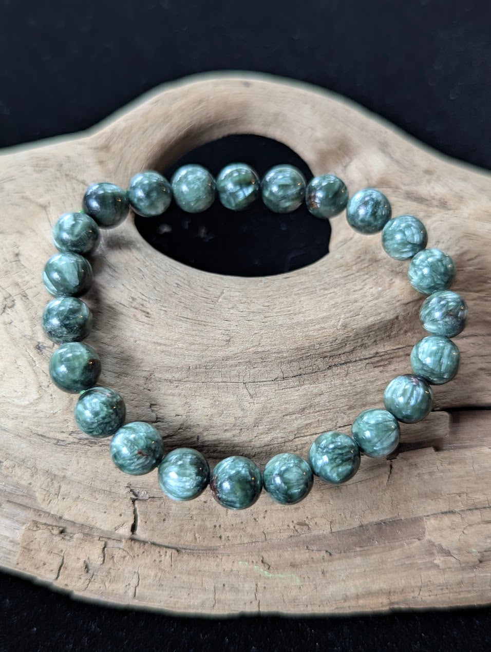 8mm Seraphinite (Clinochlore) Bracelet from Siberia, showing deep green color and silver feathering on driftwood.