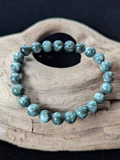 8mm Seraphinite (Clinochlore) Bracelet from Siberia, showing deep green color and silver feathering on driftwood.